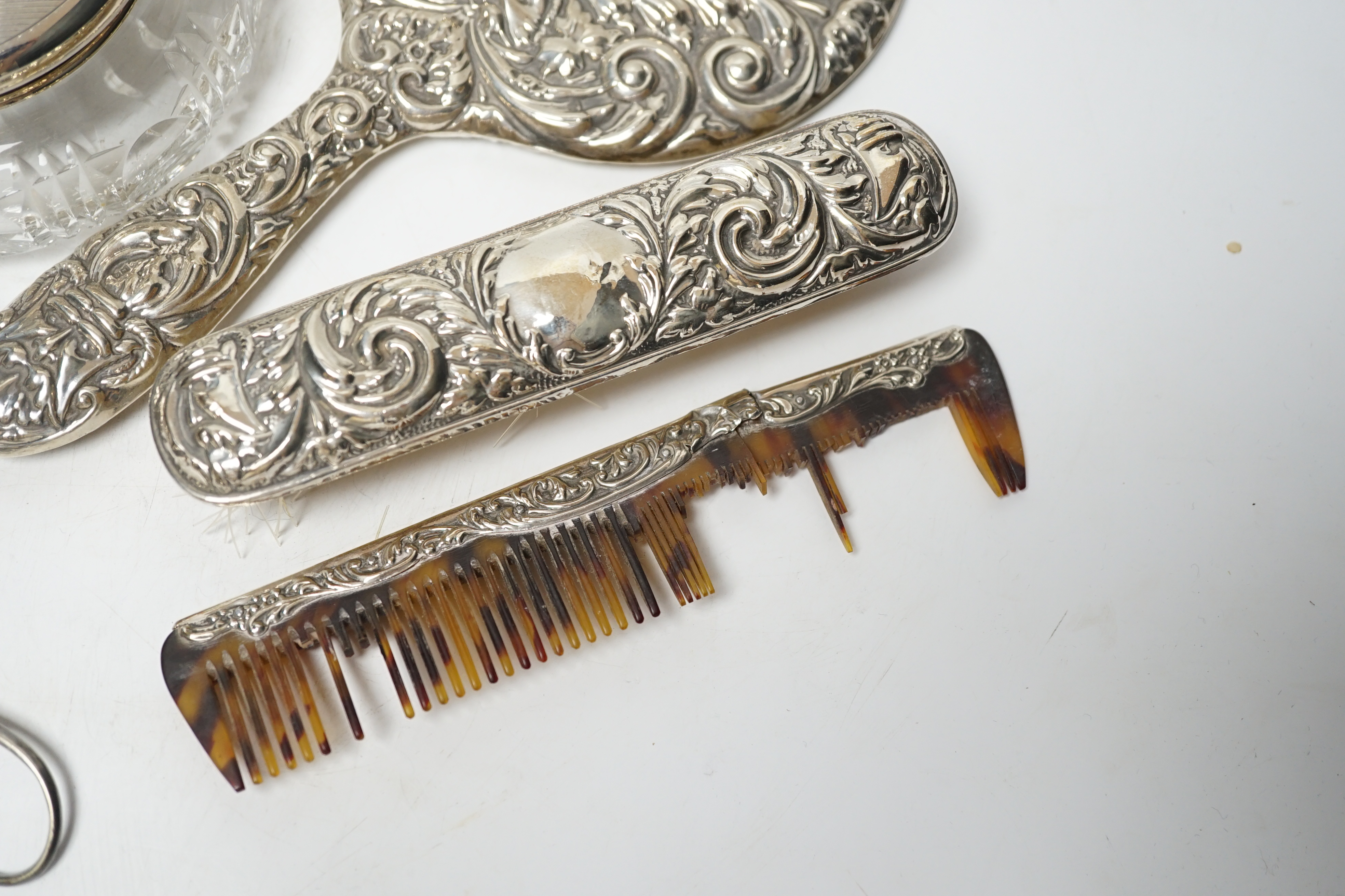 Seven assorted silver mounted glass scent bottles or toilet jars, and a repousse silver backed four piece dressing table set (a.f.) and other items including plated coffee spoons, place setting holders, etc.